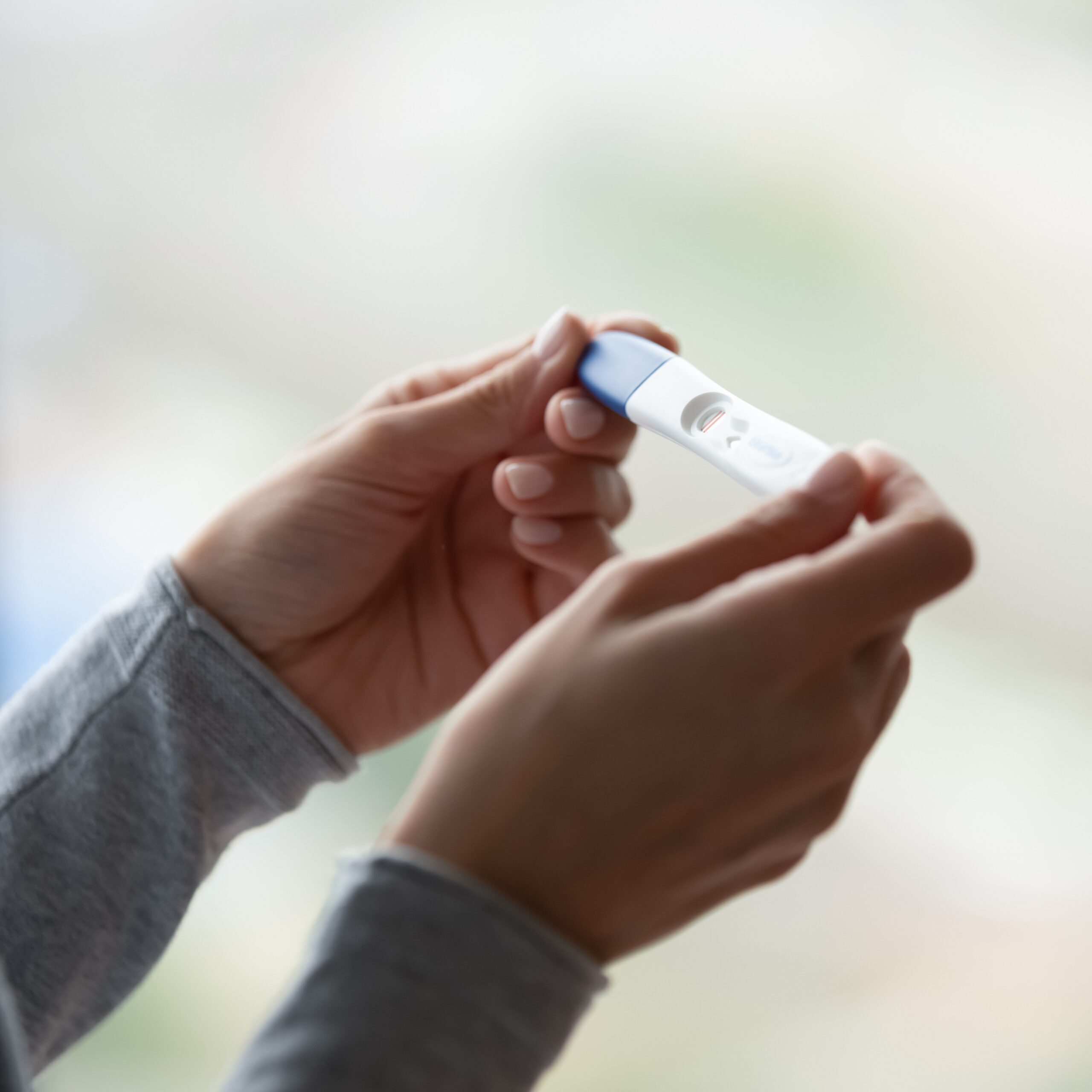 Close Up Of Woman Hands Holding Positive Home Pregnancy Test