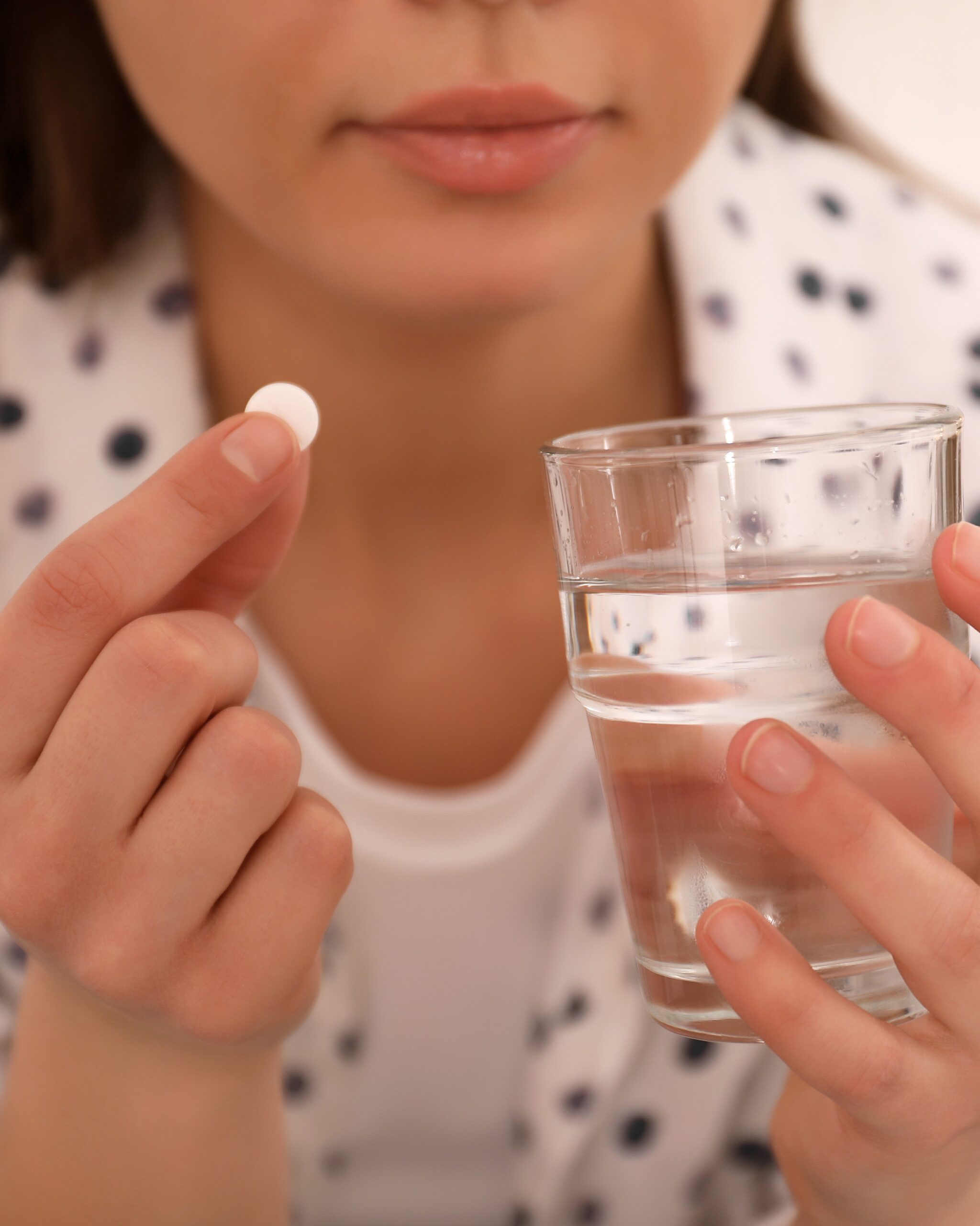 Young Woman Taking Abortion Pill Indoors, Closeup